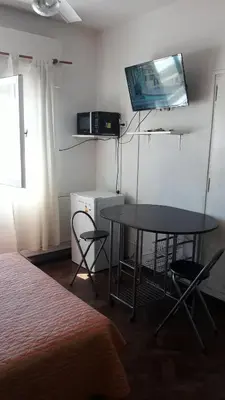 a room with a table and a television and a bed at CARLOS PAZ, Dpto, 3 Huésped in Villa Carlos Paz