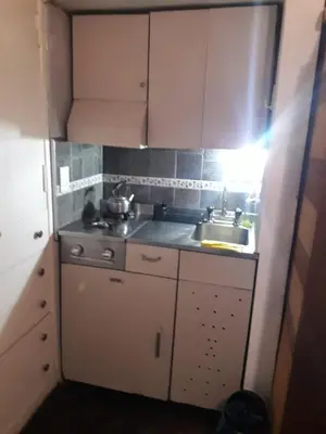a small kitchen with white cabinets and a sink at CARLOS PAZ, Dpto, 3 Huésped in Villa Carlos Paz