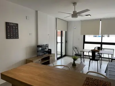 a living room with a table and chairs and a ceiling fan at Departamentos Céntricos Exclusivos in Villa Carlos Paz