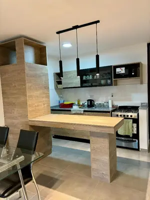 a kitchen with a large wooden table in a room at Departamentos Céntricos Exclusivos in Villa Carlos Paz
