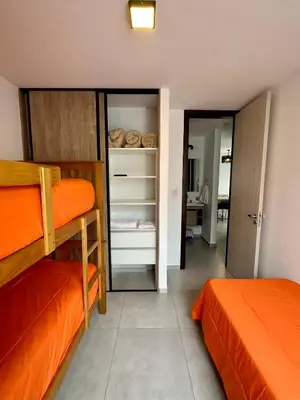 a bedroom with two bunk beds and an open closet at Departamentos Céntricos Exclusivos in Villa Carlos Paz