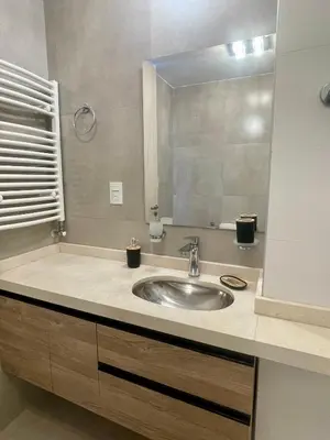 a bathroom with a sink and a mirror at Departamentos Céntricos Exclusivos in Villa Carlos Paz