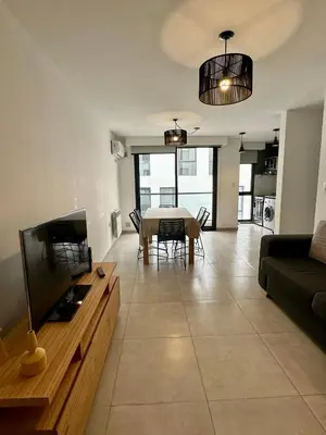 a living room with a table and a couch at Departamentos Céntricos Exclusivos in Villa Carlos Paz
