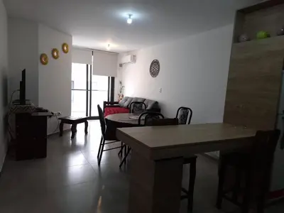 a living room with a table and some chairs at Departamentos Céntricos Exclusivos in Villa Carlos Paz