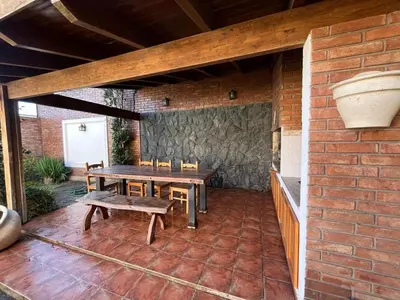 a patio with a table and chairs and a brick wall at Casa Criselo Multiespacio in Cordoba
