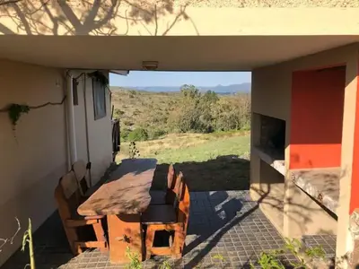 a porch of a house with a table and chairs at Cabaña Tanti Montaña del Vigía in Tanti