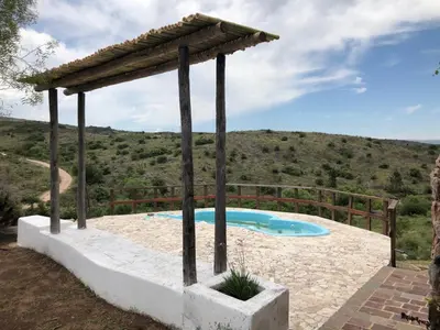 a swimming pool with a pergola next to at Cabaña Tanti Montaña del Vigía in Tanti