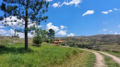 a dirt road leading to a house on a hill at Cabaña Tanti Montaña del Vigía in Tanti