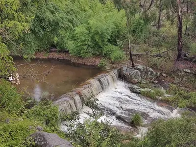 a waterfall in the middle of a river at Cabaña Tanti Montaña del Vigía in Tanti