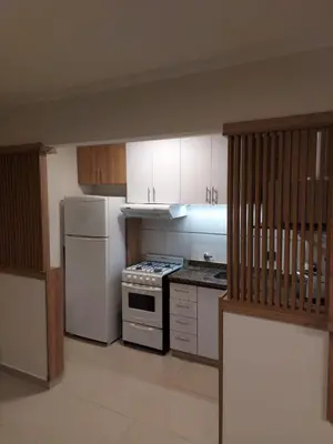 a kitchen with white cabinets and a stove and refrigerator at Nova Apartament in Cordoba