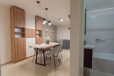 a dining room with a table and chairs and a tub at Nova Apartament in Cordoba