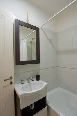 a bathroom with a sink and a tub and a mirror at Nova Apartament in Cordoba