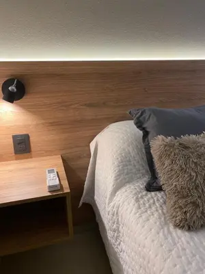 a bedroom with a bed with a wooden head board at Nova Apartament in Cordoba
