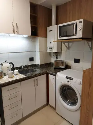 a kitchen with a washing machine and a microwave at Nova Apartament in Cordoba