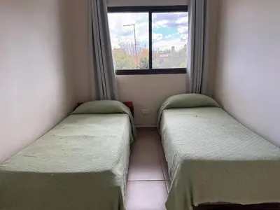 two beds in a small room with a window at Monte Loft in Mina Clavero