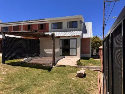 a house with a fence in front of a yard at Monte Loft in Mina Clavero