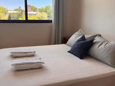 a bedroom with two towels on a bed with a window at Monte Loft in Mina Clavero
