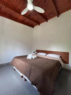 a bedroom with a bed with a ceiling fan at Bungalow a metros del centro in Villa General Belgrano