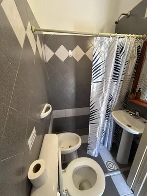 a small bathroom with a toilet and a sink at Bungalow a metros del centro in Villa General Belgrano
