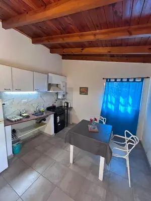 a kitchen with a table and a kitchen with a stove at Bungalow a metros del centro in Villa General Belgrano