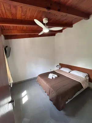 a bedroom with a bed with a ceiling fan at Bungalow a metros del centro in Villa General Belgrano