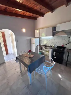 a kitchen with a table and chairs in a room at Bungalow a metros del centro in Villa General Belgrano
