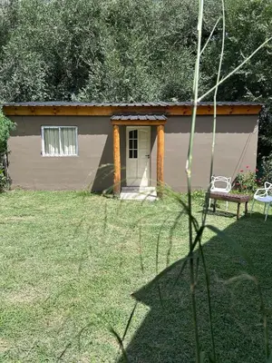 a small shed with a bench in a yard at Bungalow a metros del centro in Villa General Belgrano