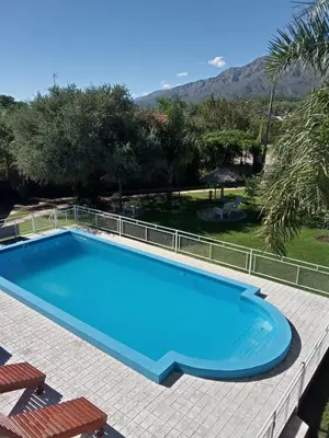 a large blue swimming pool with chairs and trees at Los Estribos Merlo in Merlo