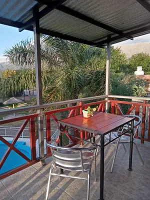a wooden table and chairs on a deck with a view at Los Estribos Merlo in Merlo