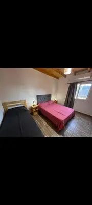 a bedroom with a red bed and a window at Manzanillas in Mina Clavero