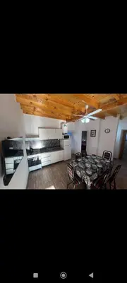 a room with a table and chairs and a kitchen at Manzanillas in Mina Clavero