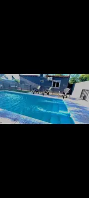 a picture of a swimming pool with two benches at Manzanillas in Mina Clavero
