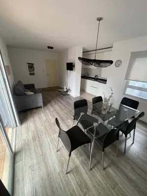 a living room with a glass table and chairs at Finlay Departamento in Villa Carlos Paz
