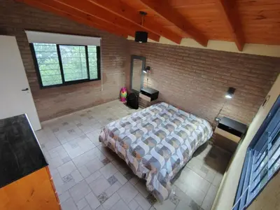 a bedroom with a bed and a brick wall at Cabañas mauro in Tanti