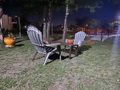 two chairs and a table in a park at night at Cabañas mauro in Tanti
