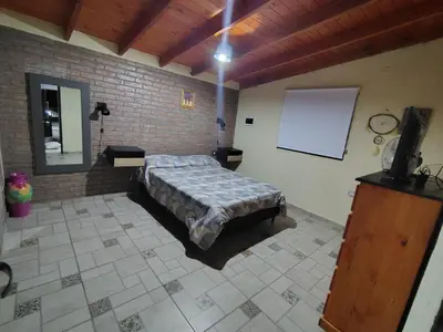 a bedroom with a bed and a brick wall at Cabañas mauro in Tanti