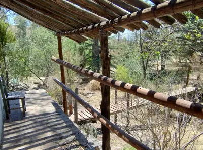 a wooden porch with a bench on a deck at Cabaña Tanti Estancia La Escondida in Tanti