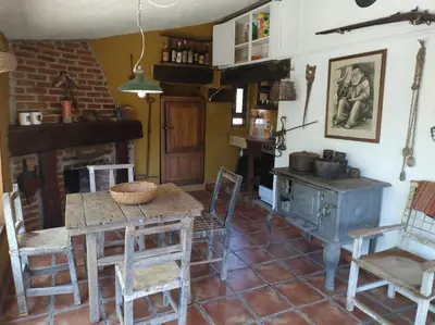 a living room with a table and a stove at Cabaña Tanti Estancia La Escondida in Tanti