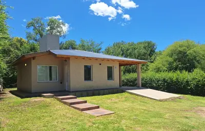 a small house with a porch and some grass at Casa Rincon in Villa General Belgrano