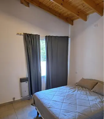 a bedroom with a bed and a window at Casa Rincon in Villa General Belgrano