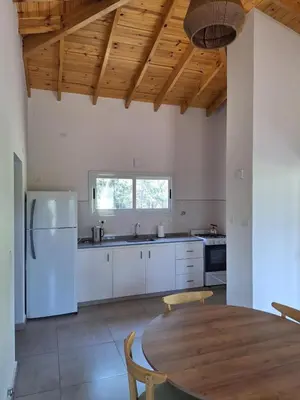 a kitchen with white appliances and a wooden ceiling at Casa Rincon in Villa General Belgrano
