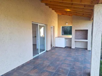 an empty porch of a house with a wooden ceiling at Casa Rincon in Villa General Belgrano