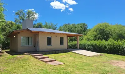a small house in a yard with a grass field at Casa Rincon in Villa General Belgrano
