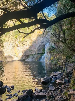 a waterfall in front of a river with rocks at Cabaña kempes Córdoba in Cordoba