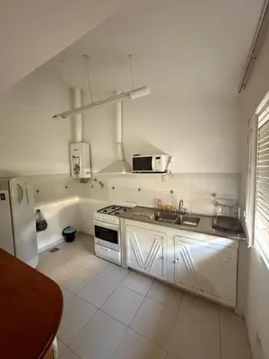a white kitchen with a sink and a stove at Cabaña kempes Córdoba in Cordoba