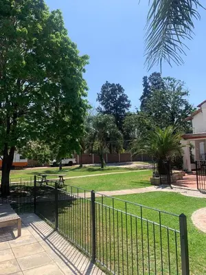 a fence in front of a park with a bench at Cabaña kempes Córdoba in Cordoba