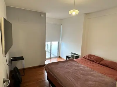 a bedroom with a bed and a large window at Departamento Nueva Córdoba in Cordoba