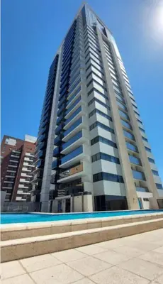 a tall building with a swimming pool in front of it at Departamento Nueva Córdoba in Cordoba