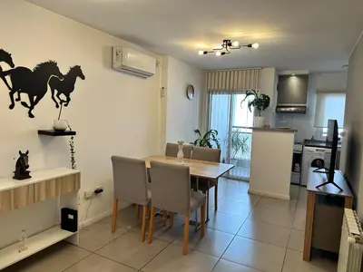 a kitchen and dining room with a table with horses on the wall at Departamento Nueva Córdoba in Cordoba