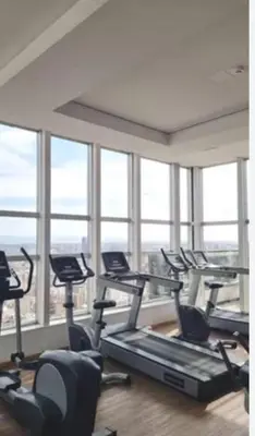 a gym with several tread machines in a room with windows at Departamento Nueva Córdoba in Cordoba